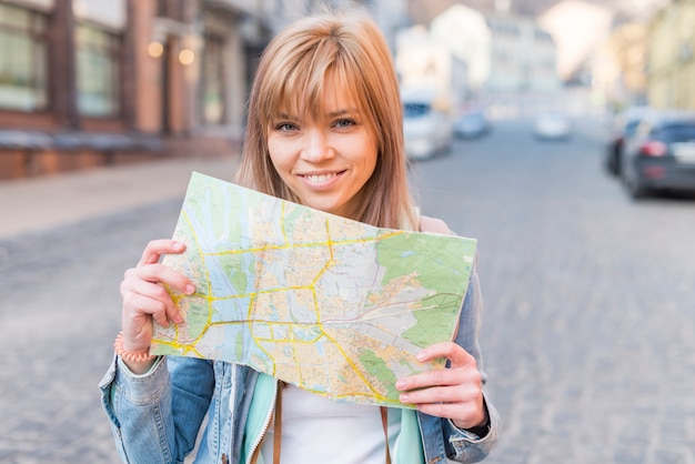 Portrait, de, a, souriant, touriste femme, debout, sur, rue, projection, carte