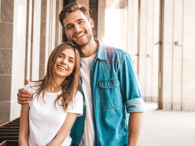 Portrait de souriante belle fille et son beau petit ami. Femme en vêtements de jeans d'été décontracté. . Étreindre