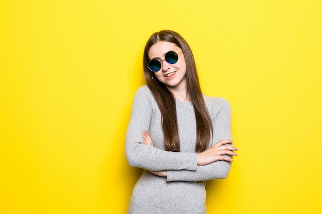 Portrait, de, sourire, belle femme, dans, lunettes soleil, et, robe, contre, de, mur jaune