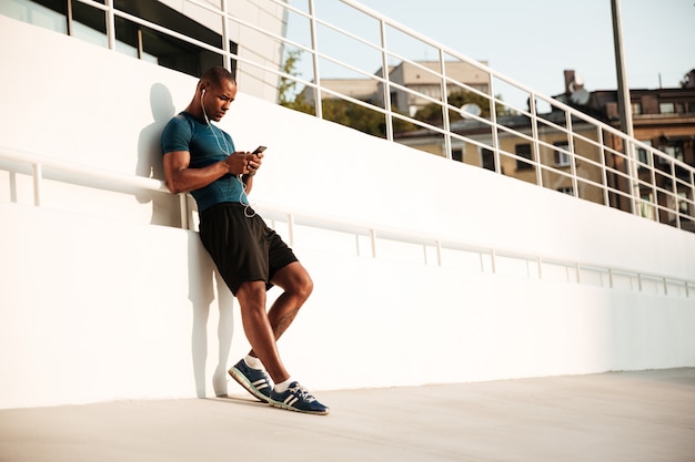 Portrait d'un sportif afro-américain apte à écouter de la musique