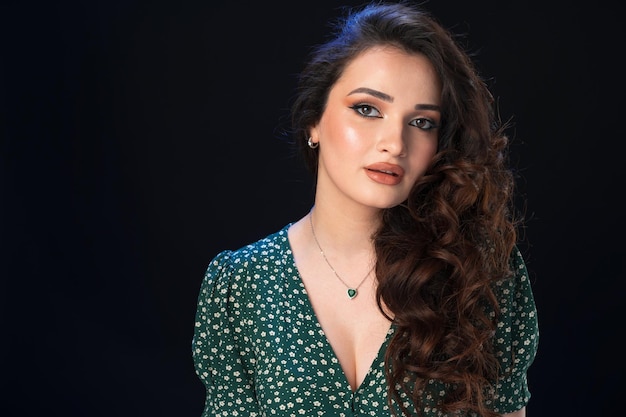 Portrait en studio d'une belle jeune femme brune sur fond noir