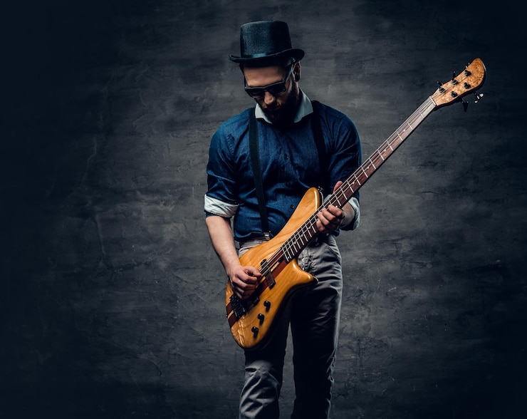 Photo gratuit portrait en studio du bassiste hipster vêtu d'un chapeau cylindrique.