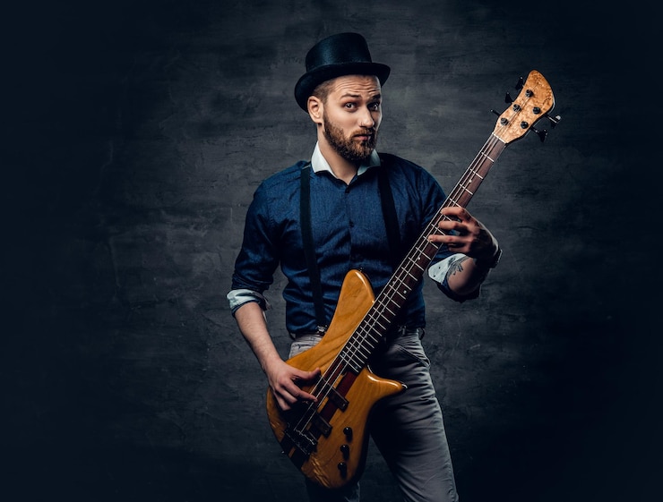 Photo gratuit portrait en studio du bassiste hipster vêtu d'un chapeau cylindrique.