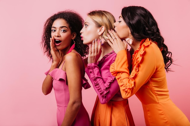 Portrait en studio de filles africaines et européennes Lating jeune femme parlant avec des amis sur fond clair