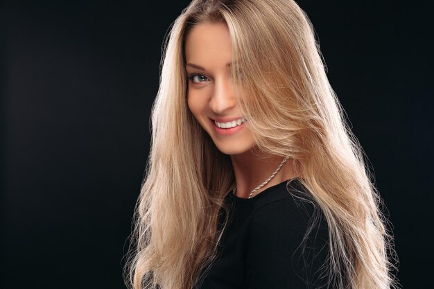 Portrait en studio d'heureuse belle fille souriant à la caméra