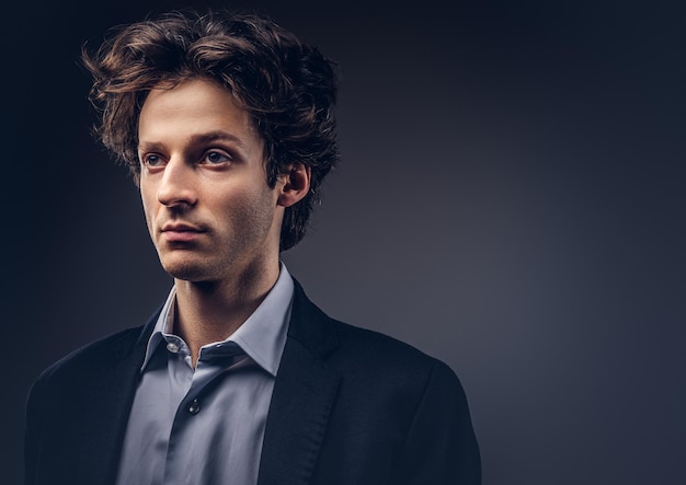 Portrait en studio d'un homme sensuel élégant avec une coiffure dans un costume décontracté