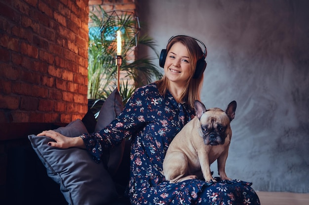 Portrait en studio d'une jolie blonde heureuse dans une pièce avec un intérieur loft.