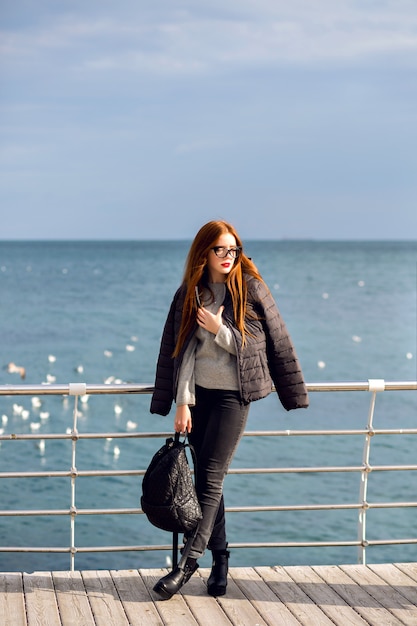 Portrait de style de vie automne en plein air d'une femme élégante marchant seule sur la plage, vue imprenable sur la mer, voyage seul, mode de rue.