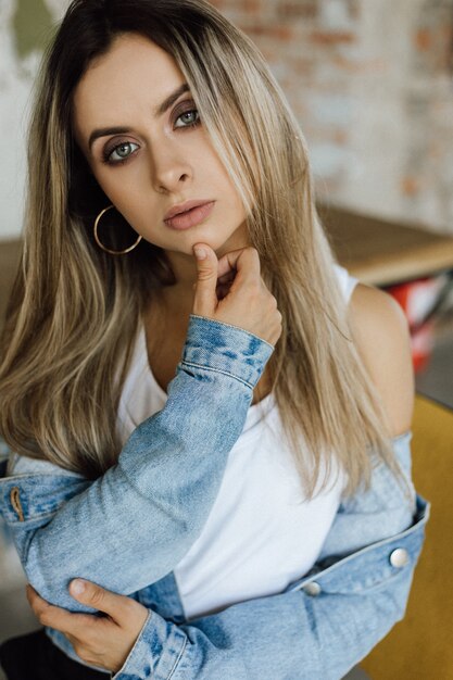 Portrait de superbe jeune femme blonde vêtue d&#39;une veste en jean casual bleu