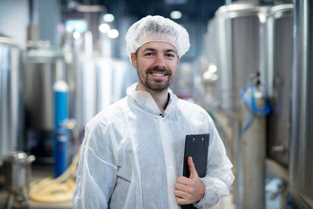 Portrait de technologue souriant en usine industrielle
