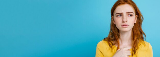 Portrait en tête d'une adolescente rousse tendre avec une expression sérieuse regardant la caméra caucasienne