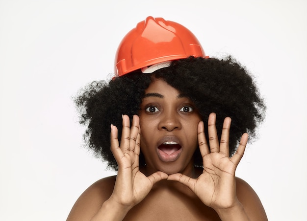 Portrait de travailleur féminin confiant en casque orange
