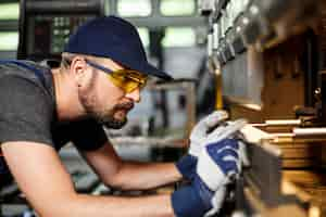 Photo gratuite portrait de travailleur près de la machine de travail des métaux