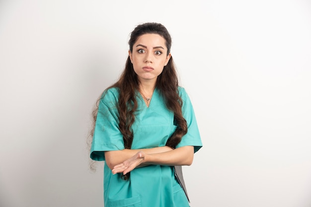 Portrait d'une travailleuse de la santé sur un mur blanc.