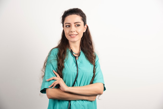 Portrait d'une travailleuse de la santé posant avec les mains croisées.