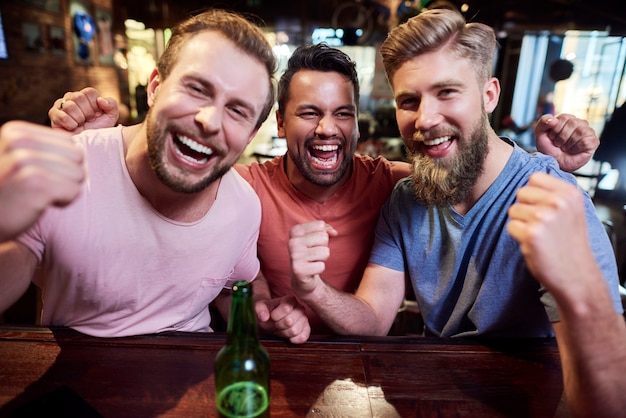 Portrait de trois hommes qui crient dans le pub