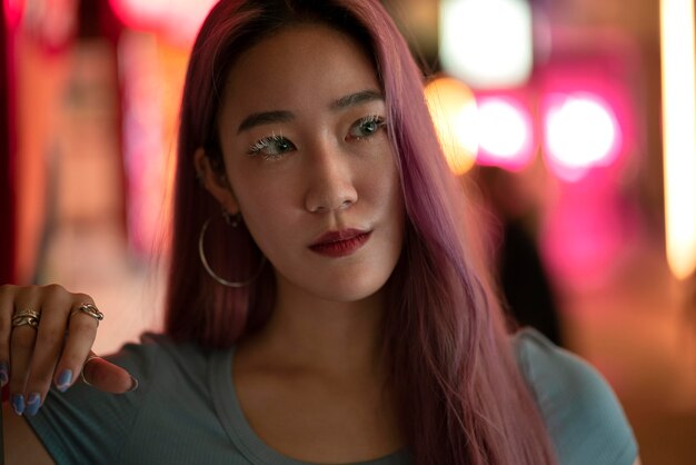 Portrait urbain de jeune femme aux longs cheveux roses