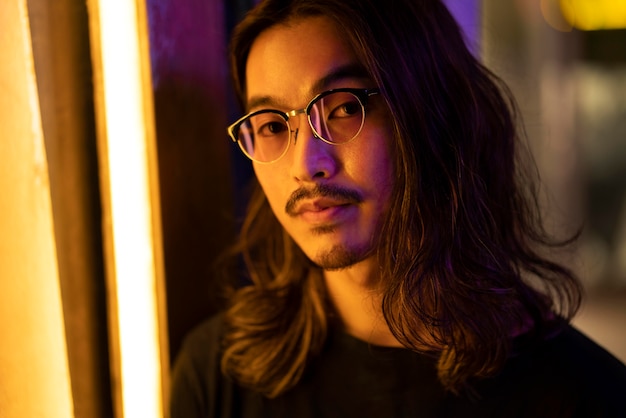 Portrait urbain de jeune homme aux cheveux longs