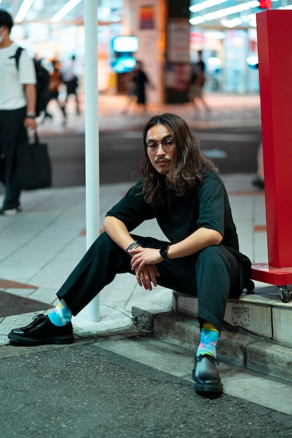 Portrait urbain de jeune homme aux cheveux longs