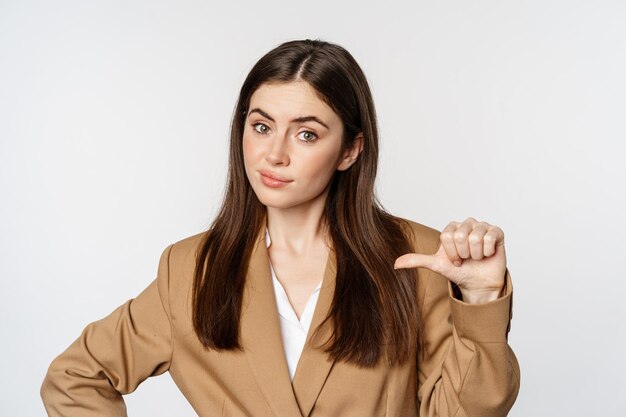 Portrait de vendeuse confiante, femme d'affaires pointant vers elle-même et ressemblant à un vrai professionnel, fond blanc.