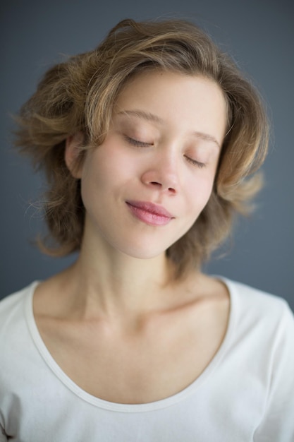 Portrait vertical d'une belle femme sensuelle fermant rêveusement les yeux