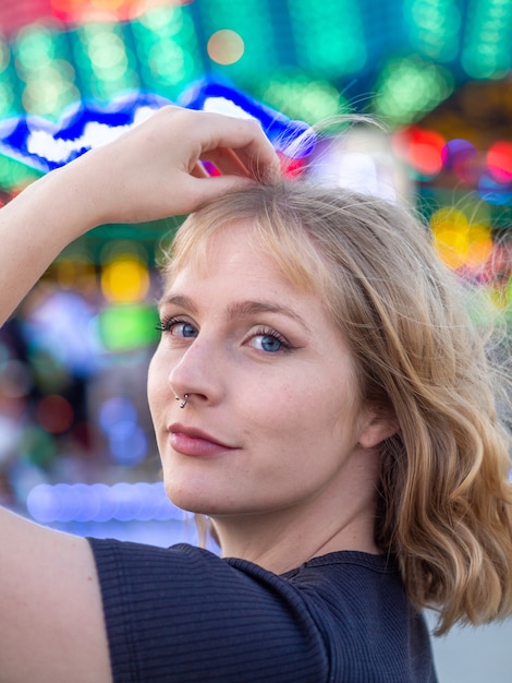 Portrait vertical d'une jeune femme blonde dans un parc d'attractions