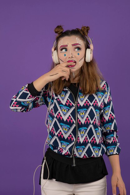 Portrait vertical de jeune fille avec un maquillage créatif et mordant son doigt. Photo de haute qualité