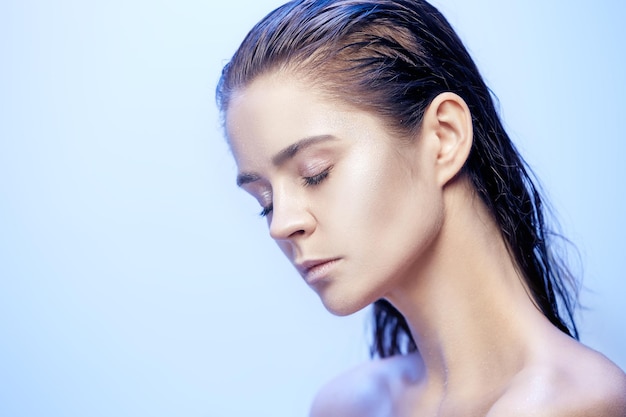 Portrait de visage de belle femme se bouchent sur fond bleu