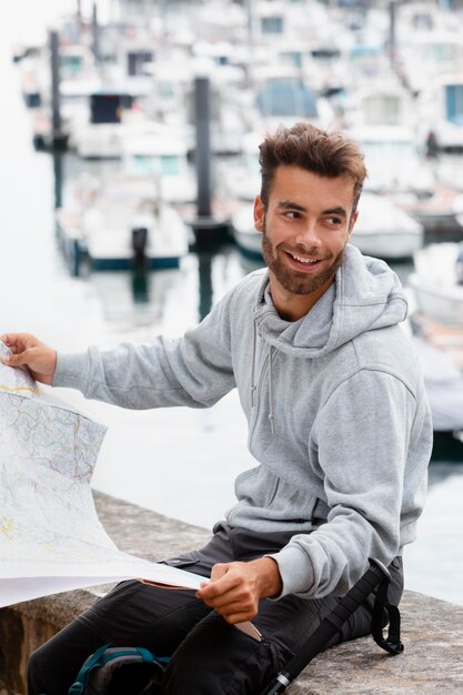 Portrait de voyageur masculin vérifiant une carte