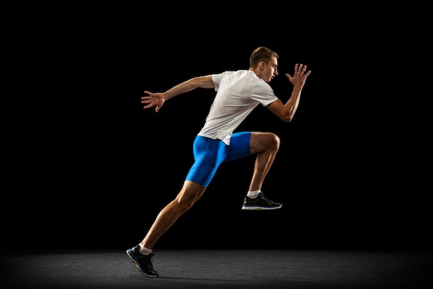 Portrat d'athlète masculin professionnel caucasien, formation de coureur d'isolement sur le noir