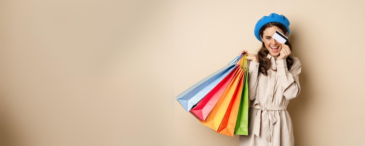 Photo gratuit portrat de fille féminine à la mode posant avec des sacs à provisions du magasin et contact de paiement par carte de crédit