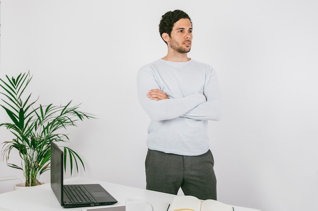 Poser dans le bureau avec les bras croisés