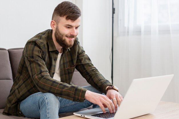 Positif jeune homme appréciant le travail à domicile