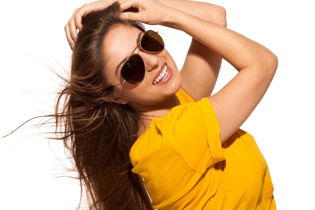 Positive jeune femme à lunettes de soleil