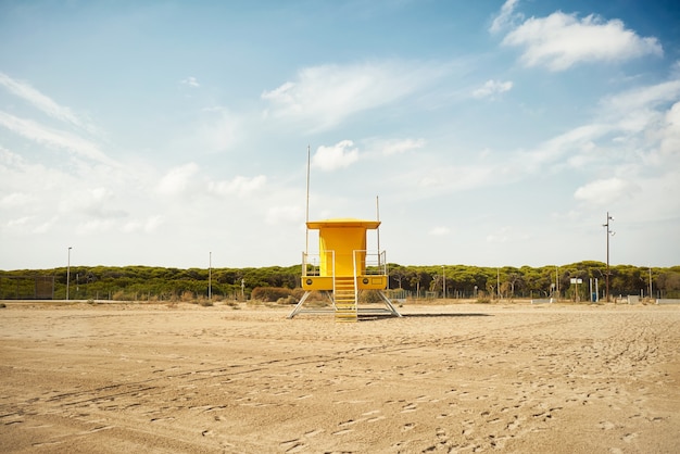 Poste de sauveteur jaune sur la plage vide