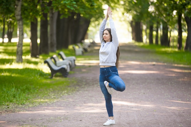 Posture de Vriksasana sur l&#39;allée du parc