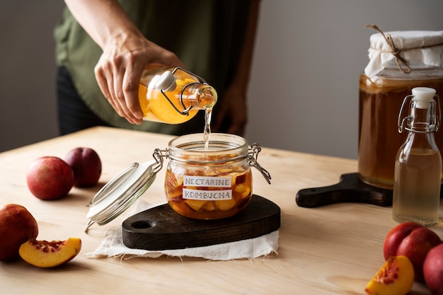 Photo gratuite pot de kombucha nectarine savoureux avec étiquette