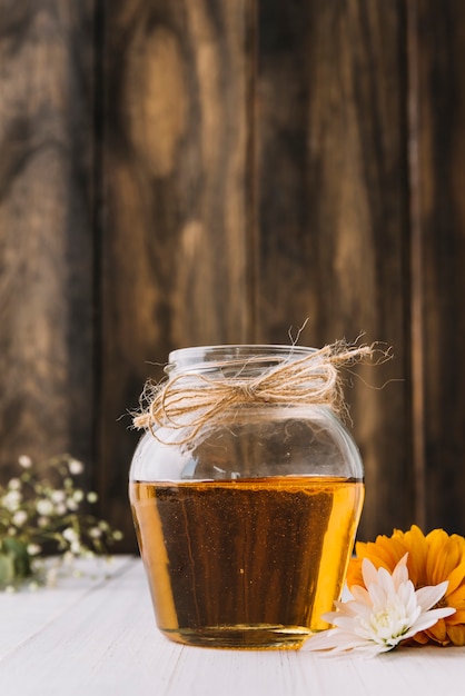 Photo gratuite pot de miel sucré et de fleurs sur le bureau