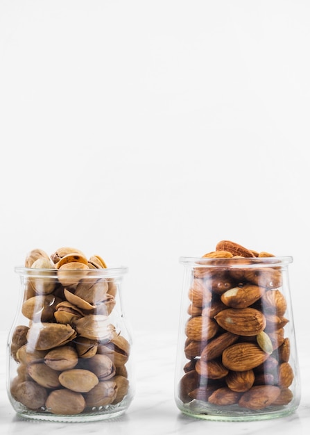 Pot de pistaches et amandes sur une surface en marbre