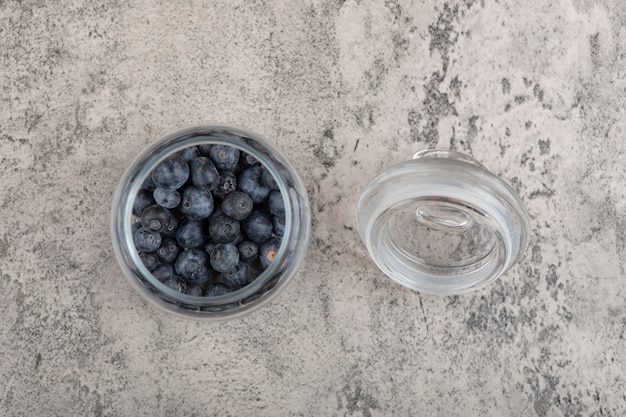 Photo gratuite pot en verre de bleuets frais délicieux sur une surface en marbre