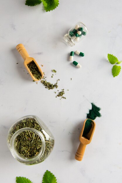 Pot de vue de dessus avec des herbes et des capsules sur la table