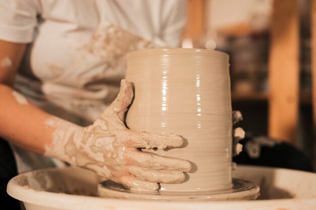 Potier féminin façonnant un pot dans un atelier de poterie