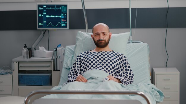 Potrait d'un homme malade triste portant un tube à oxygène nasal couché dans le mauvais