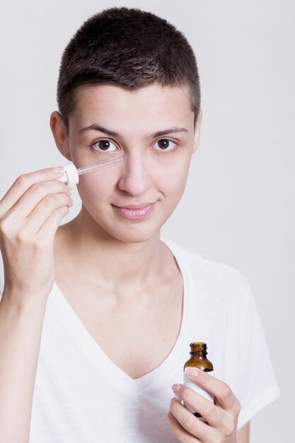 Potrait jeune femme appliquant le produit pour le visage