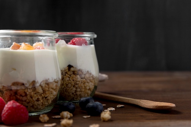 Photo gratuite pots avec yougurt et granola sur table