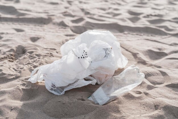 Une poubelle en plastique jetée sur le littoral sablonneux sur la plage, problème écologique