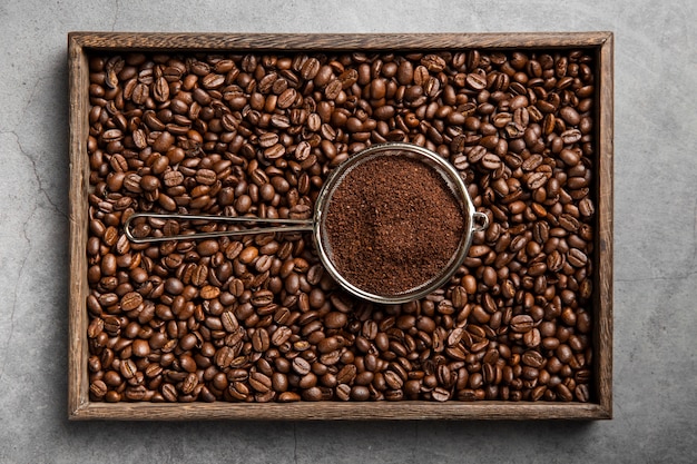 Poudre de café à plat dans une passoire et des grains de café