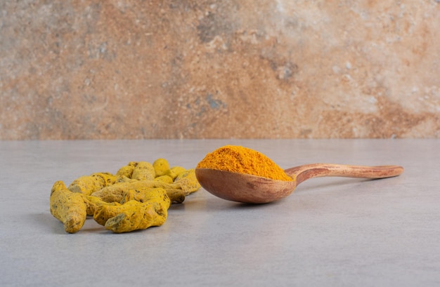 Photo gratuite poudre de curcumine mélangée dans une cuillère en bois.