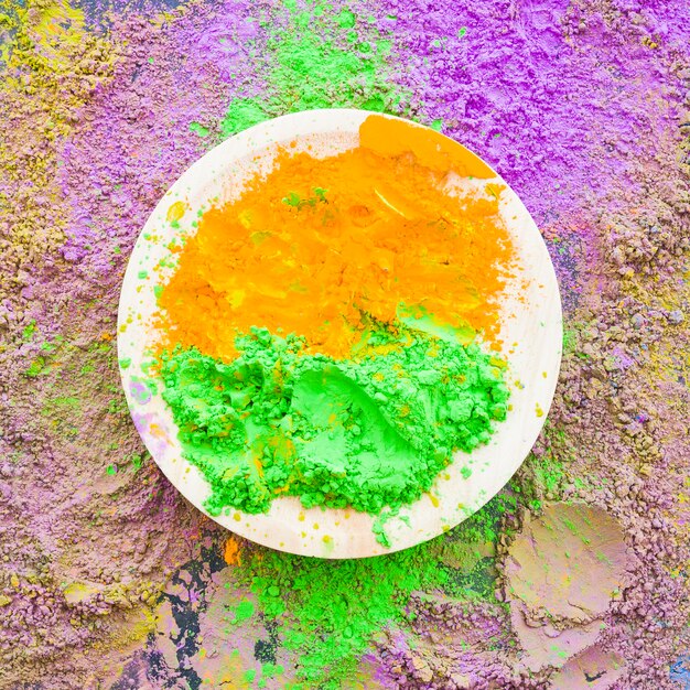 Poudre de holi traditionnel vert et orange sur assiette