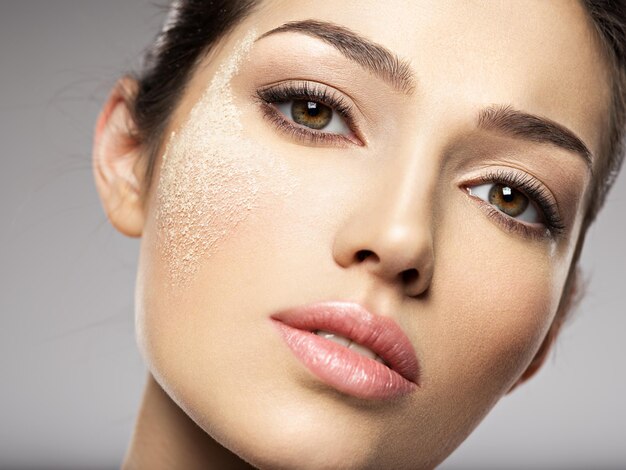 La poudre de maquillage cosmétique sèche est sur le visage féminin. Concept de traitement de beauté. La fille fait du maquillage.